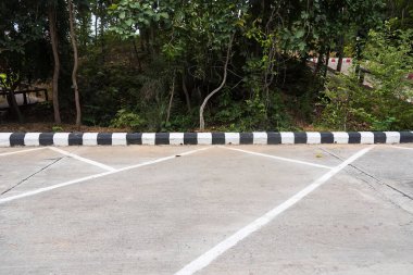 Üzerinde beyaz çizgiler olan bir otopark. Ana konuya odaklanamadım. .