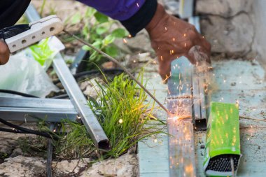 Kaynakçı evin çeşitli kısımlarını kaynaklıyor..