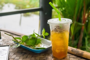 Buz gibi soğuk Longan meyve suyunu eski masada samanla kaplayın.