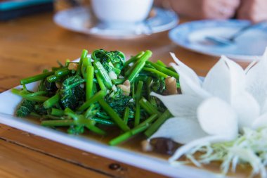 Masadaki istiridye soslu taze Chayote yaprakları. Acı biber, sarımsak ve yumurtadan çıkma.