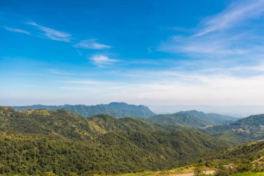 Tepelerde dağ manzarası sabahı ve yumuşak sisli yeşil orman örtüsü ve mavi gökyüzü. Tayland.