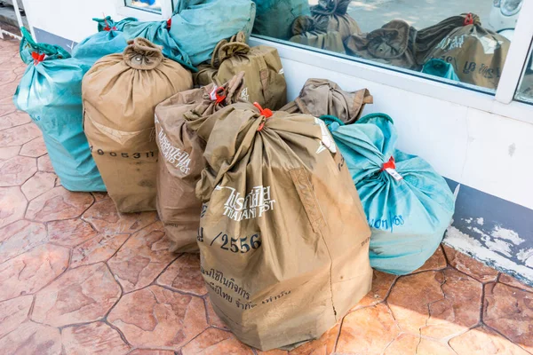 Bangkok, Thailand - March, 25, 2021 : Many big bags filled with parcels, postcards and letters being placed outside a postal office Thailand ready to be taken for delivery at Bangkok, Thailand