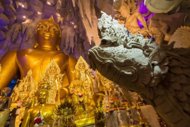 Nakhon Nayok, Tayland - 28 Mart 2021: Naga Mağarası 'nda Naga Nayok, Tayland' daki Maniwong Tapınağı 'nda ibadet eden ve şans dileyen büyük Buda.