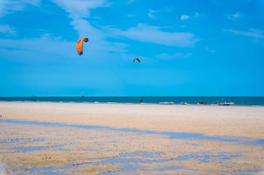 Prachuap Khiri Khan, Tayland - Nisan, 03, 2021: Hua Hin, Tayland 'da gün boyunca güneşin altında sörf yapan kimliği belirsiz Kitesurfing sporcuları.