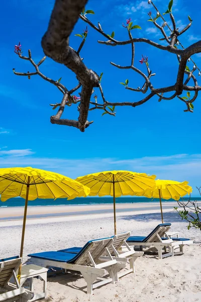 日中は暑い太陽の下でビーチチェアとビーチタイの黄色の傘 — ストック写真