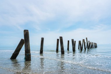 Tayland denizinde çöken eski limanın beton sütunlarının çarpıcı manzarası.