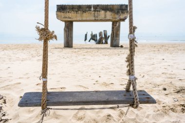 Swing at beach abandoned, undone fishing port