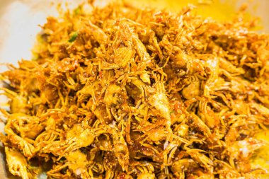 Small crab fried in a pan have a spicy and salty taste.