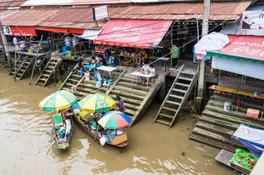 Samut Songkhram, Thailand - April, 04, 2021: Tourists shopping and boat ride around in Amphawa floating market. It is one of the most popular floating markets in Thailand.Many tourists come to travel much less due to the coronavirus outbreak.