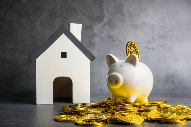 Bitcoin parası domuz kumbarası ve ahşap ev modeli masada, iş ve finans konsepti. Dijital çağda para tasarrufu. Bitcoin finansmanı