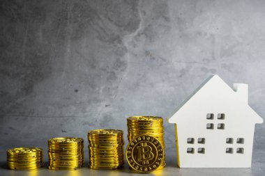 Bitcoin bozuklukları üzerinde ahşap ev modeli. Yatırım mülkiyeti, iş ve finans kavramı. Dijital çağda para tasarrufu. Bitcoin finansmanı