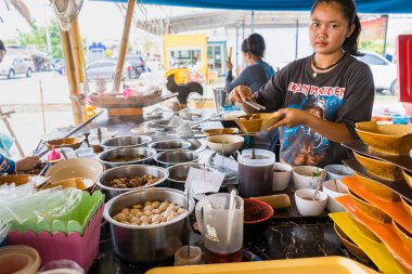 Bangkok, Tayland - 11 Nisan 2021: Kimliği belirsiz bir kadın Bangkok, Tayland 'da satmak için şehriye pişiriyor.