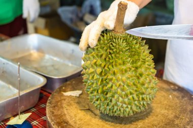 Durian meyvesini bıçakla soy, Asyalı bir kadının eli Durian meyvelerin kralıdır. Sadece yazın serbest bırakıldı..