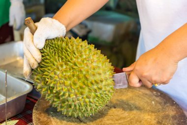 Durian meyvesini bıçakla soy, Asyalı bir kadının eli Durian meyvelerin kralıdır. Sadece yazın serbest bırakıldı..