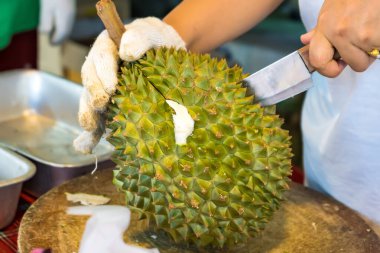 Durian meyvesini bıçakla soy, Asyalı bir kadının eli Durian meyvelerin kralıdır. Sadece yazın serbest bırakıldı..