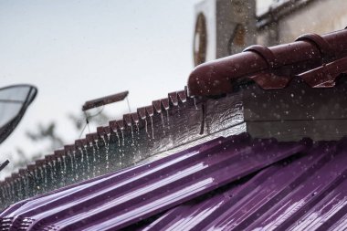 Yoğun bir yağmurdu, hava bulutluydu. Çatıdan damlayan yağmur suyu