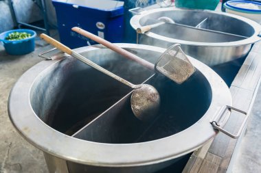 Erişte pişirmek için çeşitli sıcak çorbayla paslanmaz çelik kap. Noddle pişirmeye hazır ol. Sokak restoranı