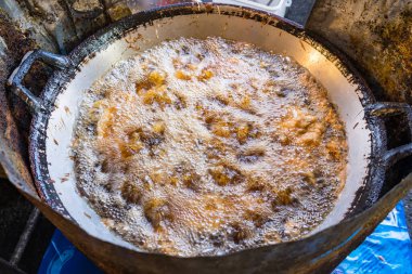 Asya usulü kızarmış tavuk Tayland pazarındaki büyük tavada palmiye yağıyla kızartılır..