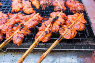 Bangkok, Tayland 'daki sokak pazarında odun çubuklu ızgarada ızgara tavuk. Tavuk ana konumuz.