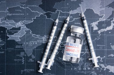 İğne, iğne, dünya haritası, yakın çekim. Aşı tıbbi konsepti COVID-19. İnsanlığın umudu kavramı.