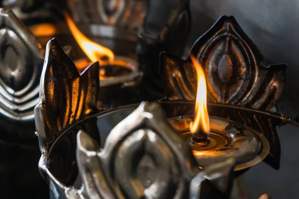 The fire and the large oil lamp illuminate in thai temple.