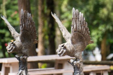 Uçuştaki Taş Heykel: Taştan heykelin güzelliğini, ayrıntılı kanatları ve güneş ışığının altındaki parkta görkemli bir görüntüsü ile yakalamak