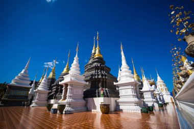 Chiang Mai, Tayland - Ocak, 06, 2026: Gökyüzünün altındaki görkemli tapınak: Görkemli bir geleneksel tapınak topluluğu, süslü detaylar ve çarpıcı altın kuleler, parlak mavi gökyüzünün bir zeminine karşı görkemli bir şekilde duruyor.