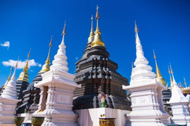 Chiang Mai, Tayland - Ocak, 06, 2026: Gökyüzünün altındaki görkemli tapınak: Görkemli bir geleneksel tapınak topluluğu, süslü detaylar ve çarpıcı altın kuleler, parlak mavi gökyüzünün bir zeminine karşı görkemli bir şekilde duruyor.