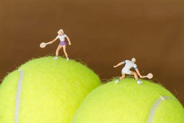 Jogador de tênis de brinquedo minúsculo em uma bola de tênis . — Fotografia de Stock