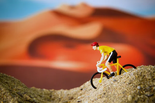 Miniature toy bicycle in desert — Stock Photo, Image