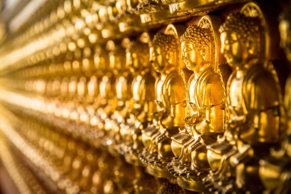 Wiele małych złoty posąg Buddy na ścianie. — Zdjęcie stockowe