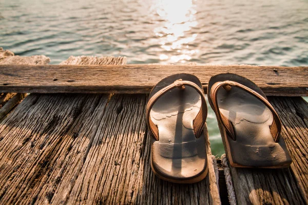 Zapatillas viejas en puente de madera . —  Fotos de Stock