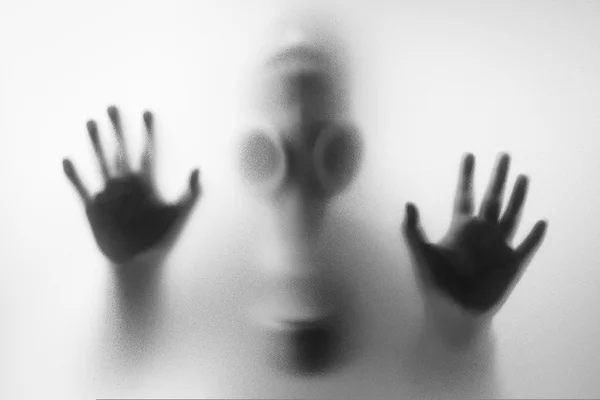 Meisje met gas maskers achter de matglas — Stockfoto
