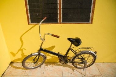 Sarı bir duvarın önünde park etmiş Bisiklet.