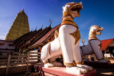 İki beyaz aslan heykeli önünde bir altın stupa.