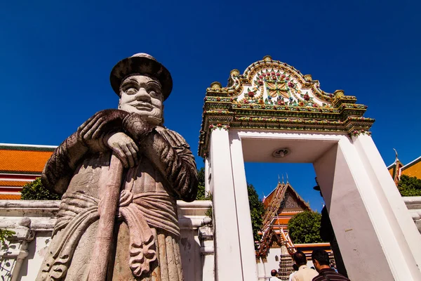 Estátua gigante fica de guarda sobre a porta do templo . — Fotografia de Stock