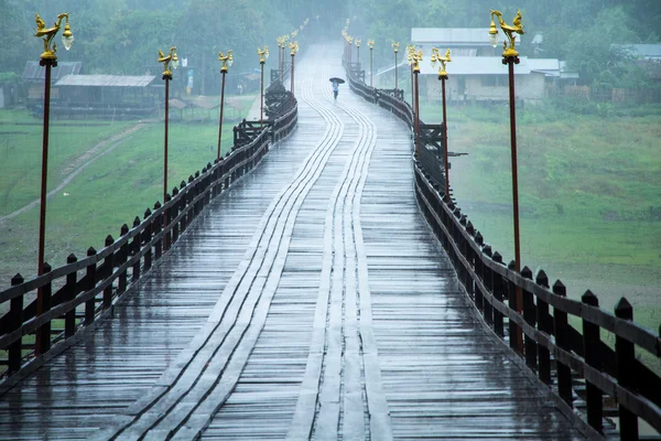 Gli studenti ombrellone passeggiate sotto la pioggia sul ponte per la scuola . — Foto Stock