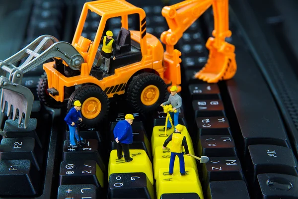 Pequenos brinquedos trabalhadores trabalhos de reparação no teclado do computador — Fotografia de Stock