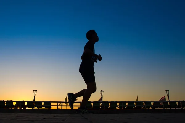 Asian men are silhouette jogging at a speed in the evening. — Stock Photo, Image