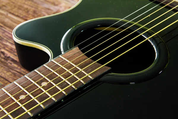 Gitara akustyczna czarny kolor na stole — Zdjęcie stockowe