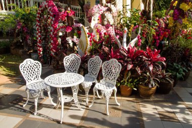 Beyaz demir bahçe masa ve sandalyeler bahçede.