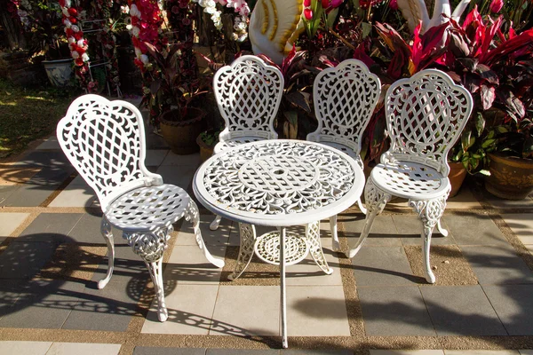 Vintage λευκό σιδερένιο τραπέζι κήπου και καρέκλες στον κήπο. — Φωτογραφία Αρχείου