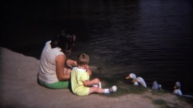 Anne oğlu kazlar besleme kullanmayı öğretmek