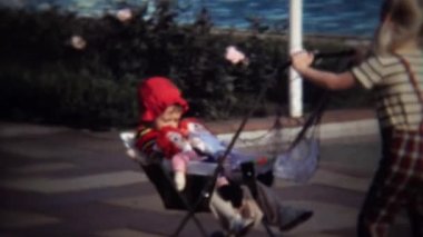 Küçük kız kardeşi bebek arabası itme