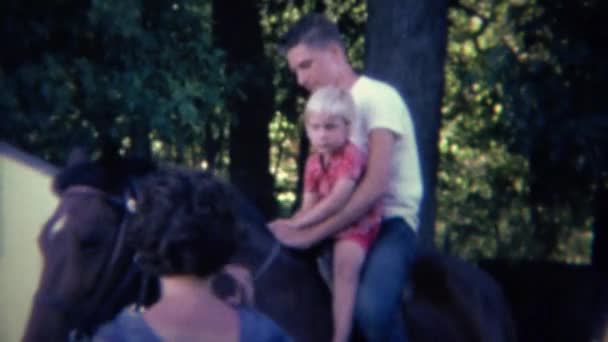 Broer helpt zus paard rijden — Stockvideo