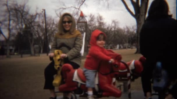 Mammas lek med barn på roterande merry gå runt — Stockvideo