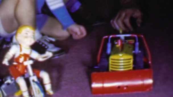 Jongen speelt speelgoed trekker en driewieler met pop — Stockvideo