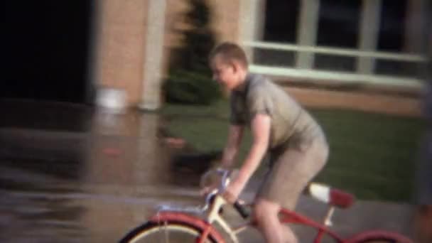 Enfants à vélo à travers la rue inondée — Video