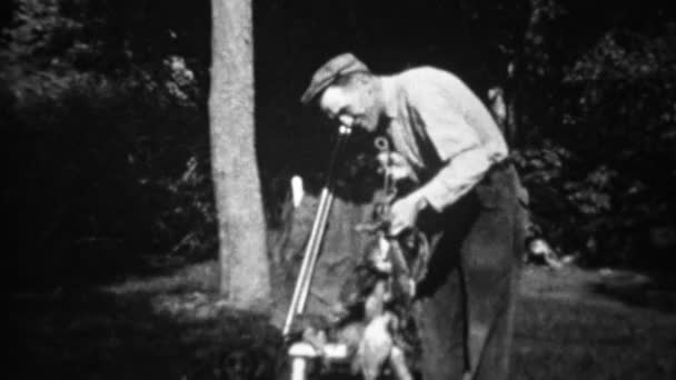 Man with stringers of dead hunted birds — Stock Video