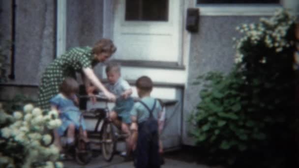 Madre prepara bicicleta de triciclo para niños — Vídeos de Stock